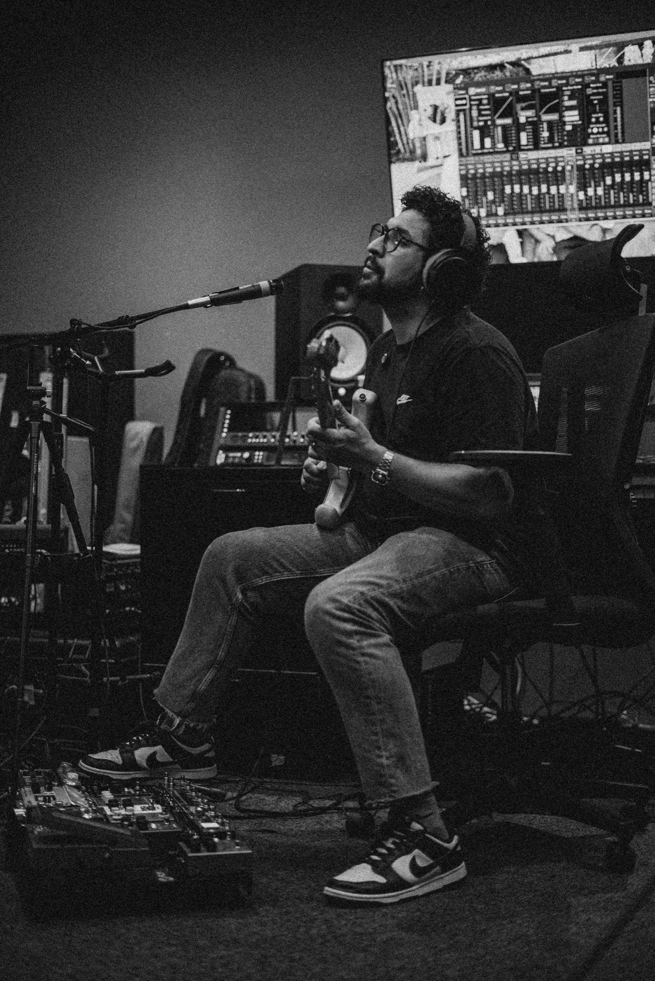 Felipe Eubank tocando guitarra no estúdio, em preto e branco